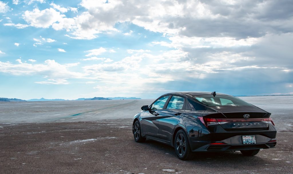 A car parked in a barren area under a cloudy sky