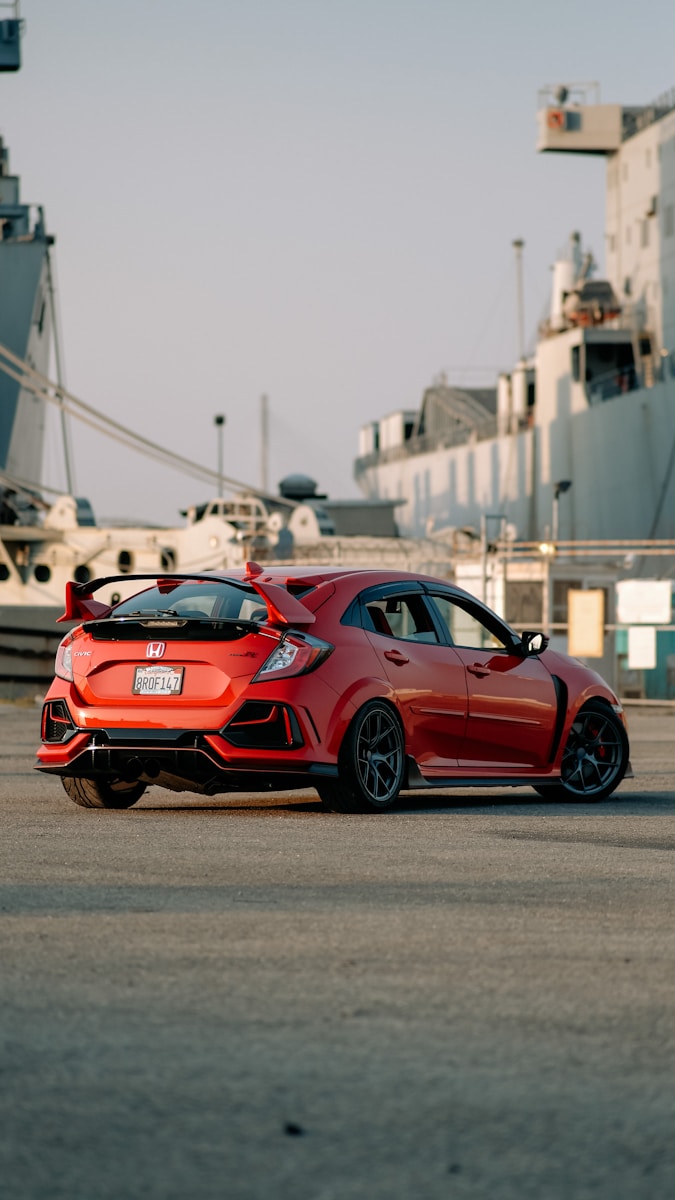 a red sports car parked in front of a ship