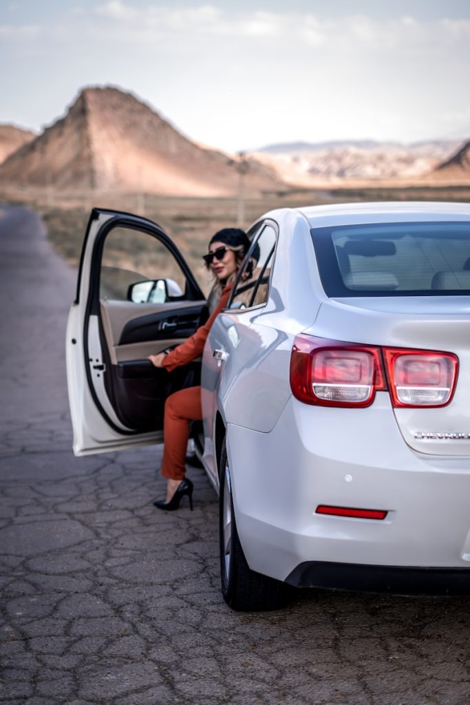 a woman sitting in the back of a white car